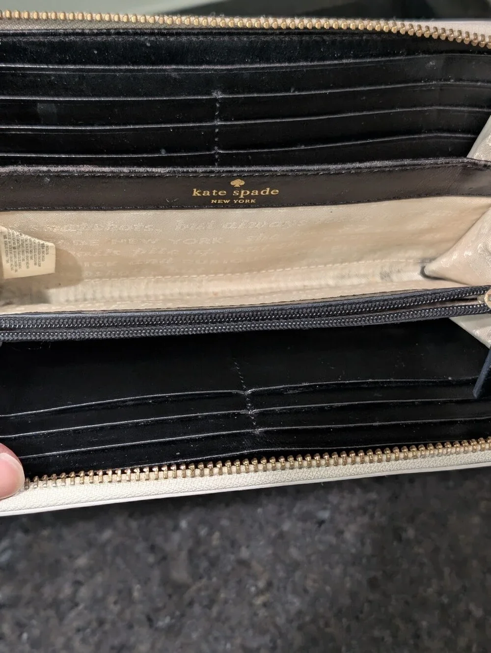 Kate Spade cream zip-around wallet with black sunglasses applique